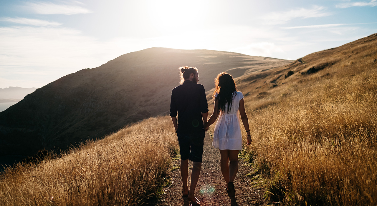 草原を歩くカップル